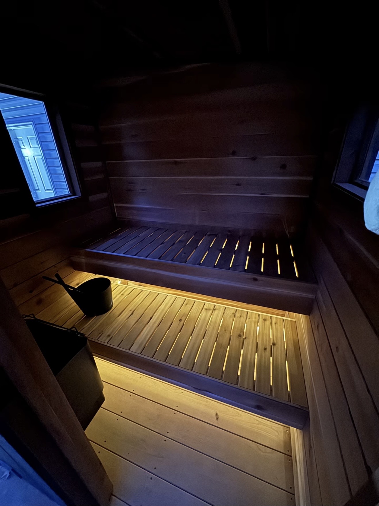 Warm lighting beneath the cedar sauna benches